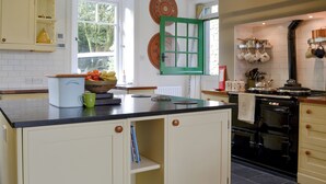 A kitchen with a central island, a stove, and a window with a view of greenery. - 4 bedroom accommodation in Buttermere, near Keswick (Buttermere, near Keswick)