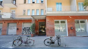 A building with a garage door, a bicycle rack, and a door with a window. - Sant'Orsola Colorful Huge Apartment (Bologna)