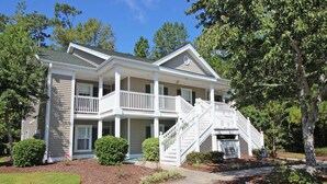 A two-story house with a front porch, a staircase, and a driveway. - TB 62C Updated 3 Bedroom 2 Bath Condo in True Blue Golf Community (Pawleys Island)