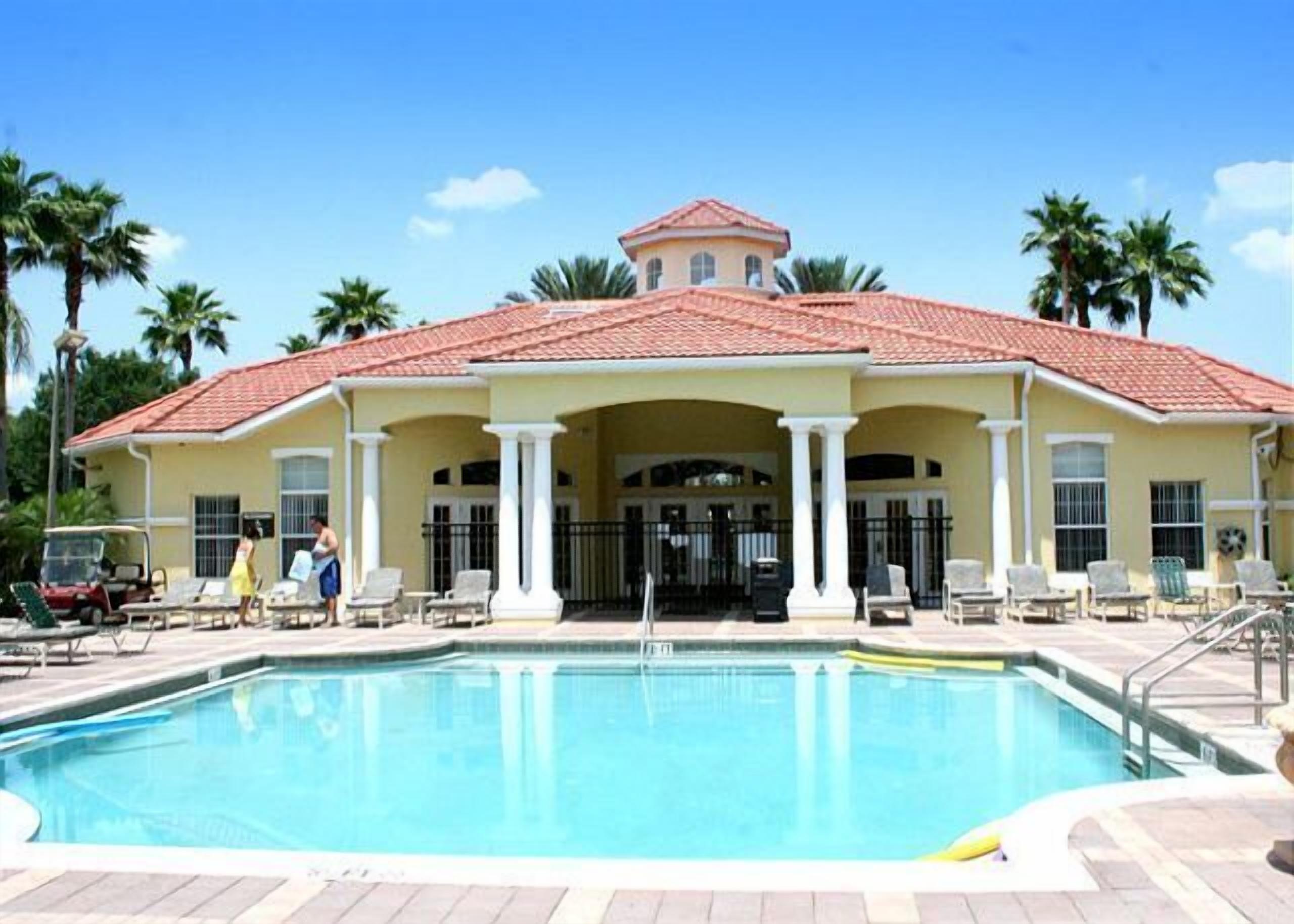A large building with a swimming pool in front.