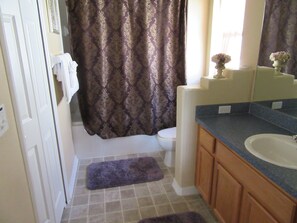A bathroom with a toilet, sink, and shower curtain.