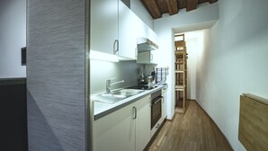 Een moderne keuken met witte kasten, roestvrijstalen apparatuur en een houten vloer.