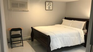 Une chambre à coucher avec un lit, une chaise, un tableau au mur et une fenêtre avec des stores.