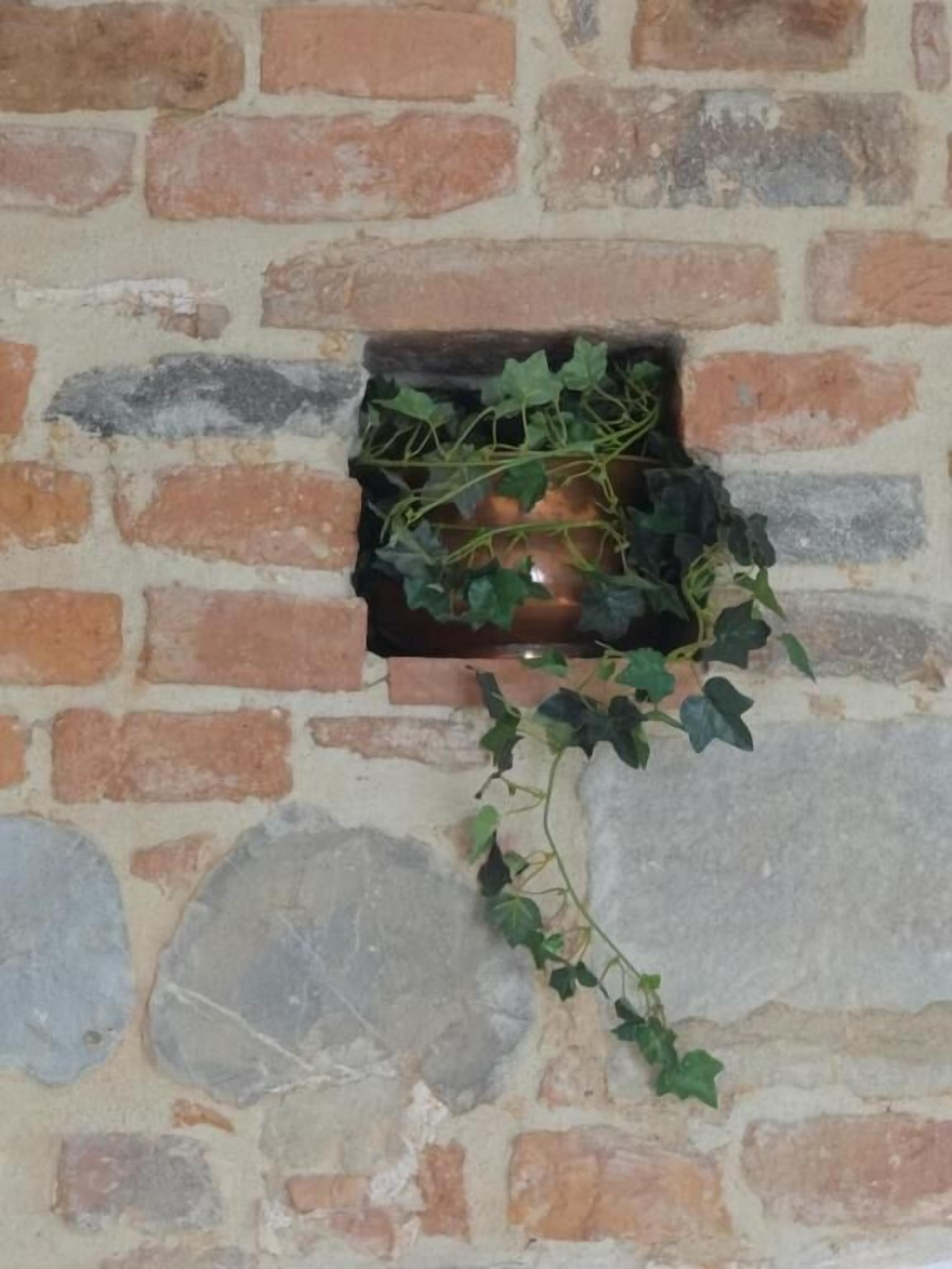 A brick wall with a small, rectangular opening.