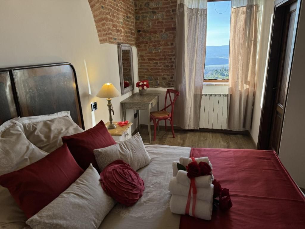 Une chambre d’hôtel avec un lit, un bureau, une chaise, une lampe et une vue sur l’extérieur.