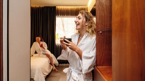 Habitación de hotel con armario de madera, una cama y un espejo.