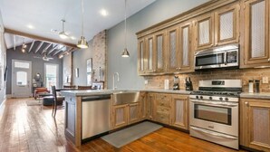 Une cuisine moderne avec des armoires en bois, des appareils électroménagers en acier inoxydable et un grand îlot central.