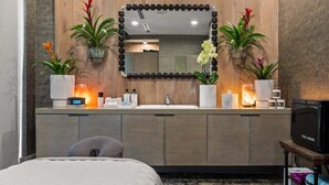 Un baño moderno con tocador de madera, un espejo grande y plantas en macetas.