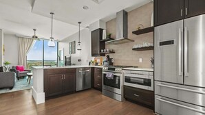 Una cocina moderna con electrodomésticos de acero inoxidable, una isla central y vistas al exterior.