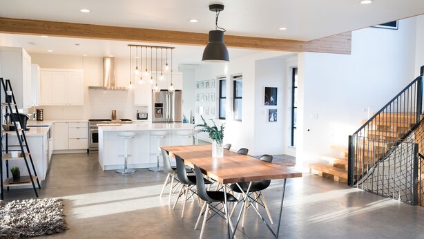 Een moderne keuken met witte kasten, een houten eiland en hanglampen.