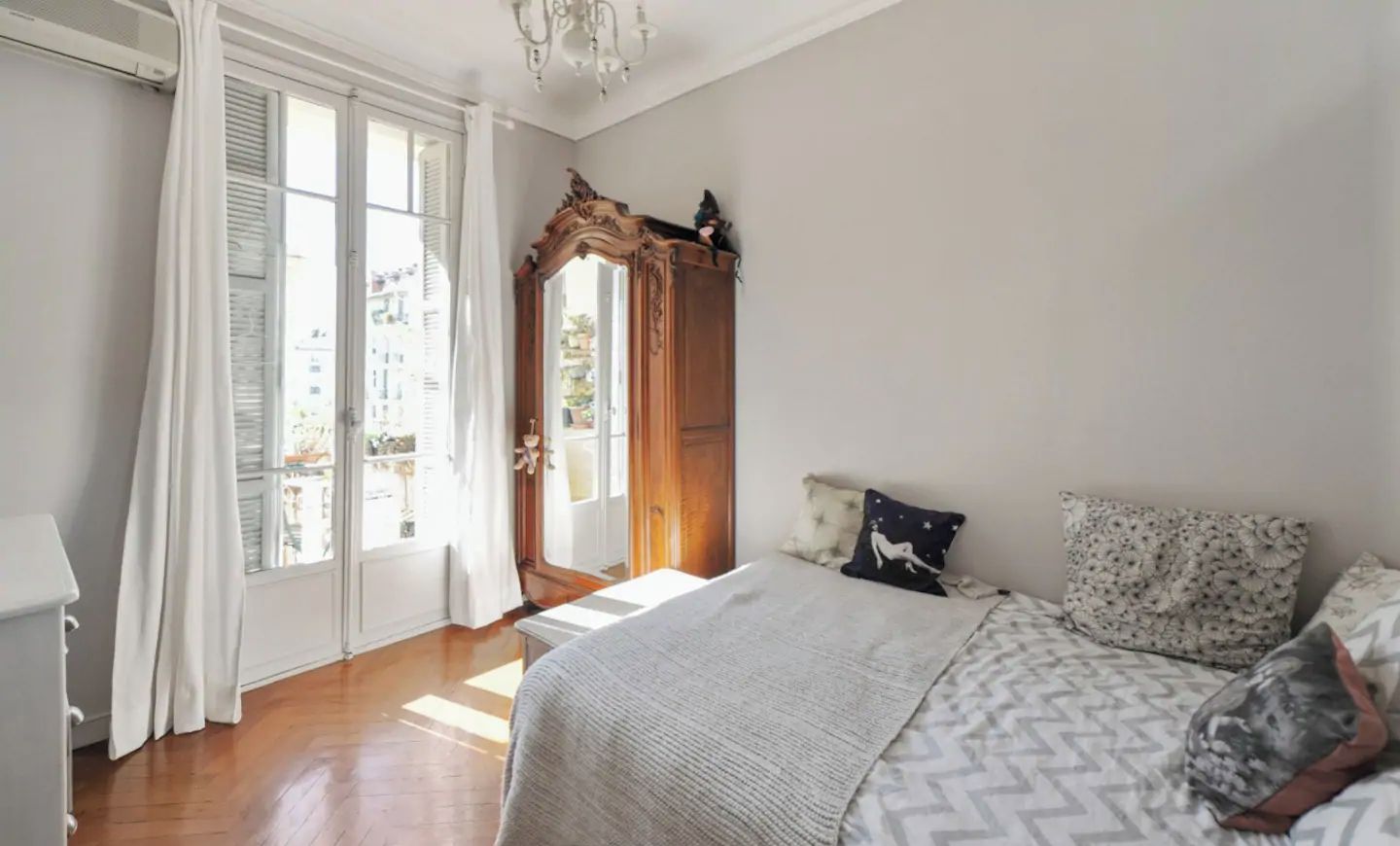 La chambre avec son lit queen size donnant sur le balcon