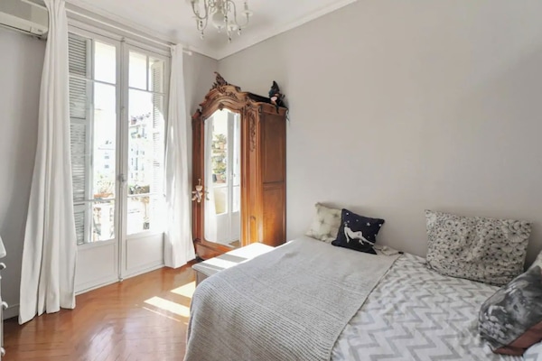 La chambre avec son lit queen size donnant sur le balcon