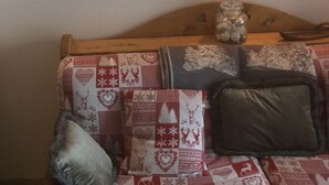 Una habitación acogedora con un cabecero de madera, una colcha acolchada y un cuadro de un lobo en la pared.