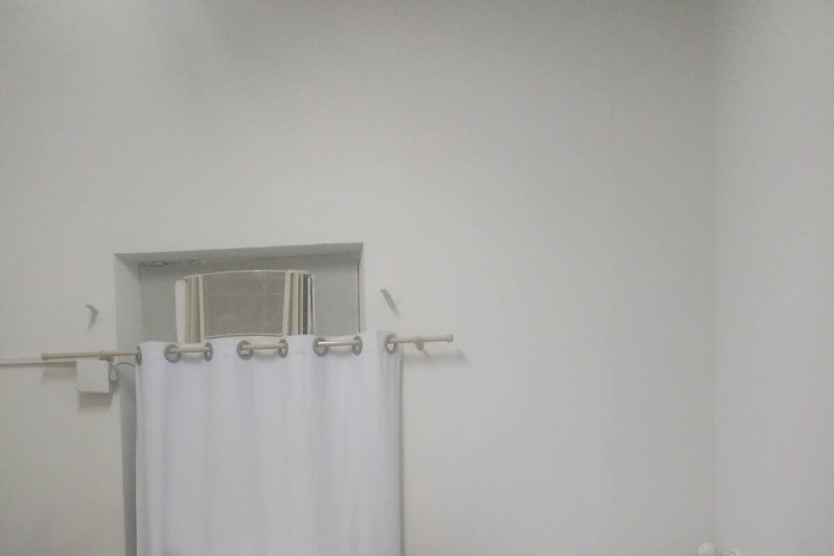 A bunk bed with a window and a curtain.