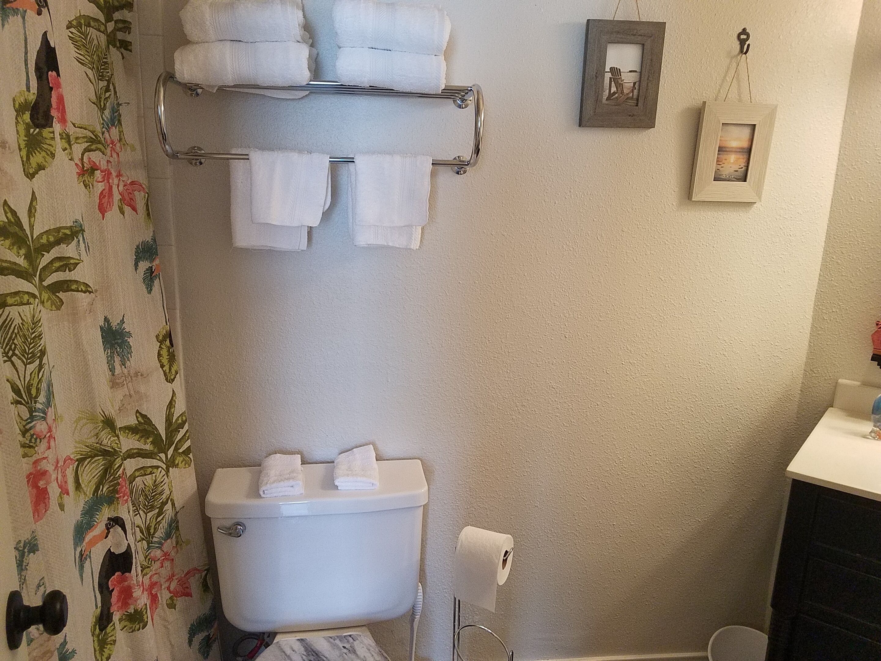 A bathroom with a toilet, a towel rack, and a toilet paper holder.