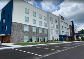 A multi-story hotel with a stone facade, multiple windows, and a parking lot.
