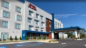Un hôtel Hampton Inn & Suites doté d’une façade moderne, d’une entrée couverte et de places de stationnement réservées aux personnes handicapées.