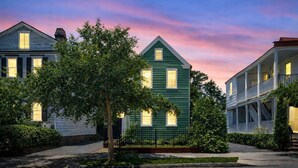 A row of three-story houses with a tree in the foreground, a gravel driveway, and a clear sky. - Historic Charleston Style House (Charleston)