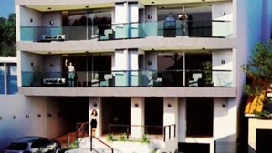 A multi-story building with balconies, a covered entrance, and a parking area. - Edificio Mirage - Zona Vip de Asunción (Asunción)