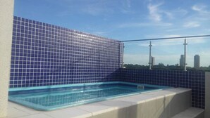 A rooftop swimming pool with blue tiles, surrounded by a metal railing, and a cityscape in the background. - Edificio Mirage - Zona Vip de Asunción (Asunción)