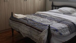 A bedroom with a bed, wooden wardrobe, and a window with a view of buildings. - Edificio Mirage - Zona Vip de Asunción (Asunción)