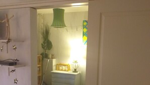 A bedroom with a bed, a dresser, a lamp, and a clock on the wall. - The secret of good taste. (Vaulx-en-Velin)