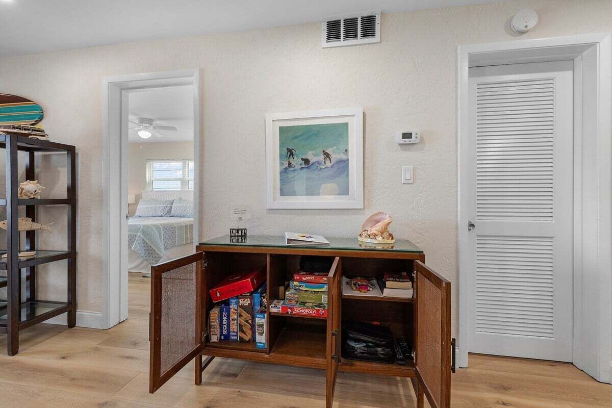 A room with a wooden desk, bookshelves, a framed picture, and a closed door.