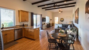 A spacious kitchen with wooden cabinets, a central island, and a dining area with a round table and chairs. - Luxe 1BR/Studio w/Hot Tub on Templeton's Westside in the Heart of Wine Country! (Templeton)