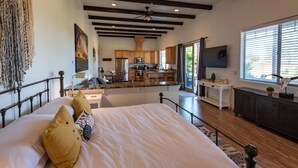 A spacious bedroom with a large bed, a view of the kitchen, and a ceiling fan. - Luxe 1BR/Studio w/Hot Tub on Templeton's Westside in the Heart of Wine Country! (Templeton)
