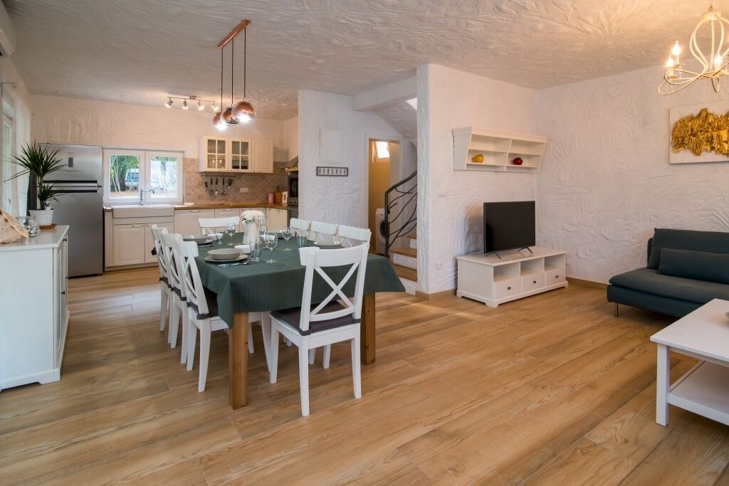 A modern living space with a dining area, kitchen, and seating area.