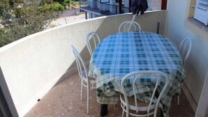 A small balcony with a round table covered by a blue and white checkered tablecloth, surrounded by white metal chairs. - Apartment in Pirovac with Terrace, Air condition, WIFI, Washing machine (4793-1) (Pirovac)