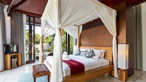 Un'ampia camera da letto con un letto grande, una testiera in legno, una televisione e una panca.