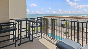 Un balcón con piscina, mobiliario exterior y vista a la playa.