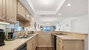 Une cuisine moderne dotée d’appareils électroménagers intégrés, d’un lave-vaisselle et d’un grand îlot central avec un évier.