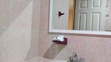 Un baño con un lavabo blanco, un espejo y una puerta.
