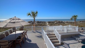 A wooden deck with outdoor furniture, a pool, and a view of the beach and ocean. - 123 Dune Ln - Oceanfront Home in N. Forest Beach w/ Private Pool & Beach Path (Hilton Head Island)
