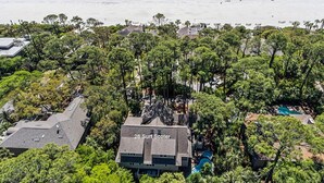 An aerial view of a coastal area with a beach, dense greenery, and a building labeled "26 Surf Scooter." - 26 Surf Scoter - 2nd Row Luxury Home in Sea Pines w/ Private Pool & Spa (Hilton Head Island)