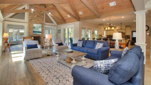 A spacious living room with a high ceiling, built-in fireplace, and large windows. - 26 Surf Scoter - 2nd Row Luxury Home in Sea Pines w/ Private Pool & Spa (Hilton Head Island)
