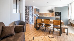 Una cucina moderna con un'isola centrale, elettrodomestici integrati e una parete decorata con pietra.