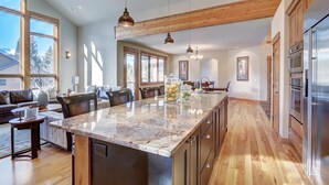 A spacious kitchen with a large island, wooden beams, and modern appliances. - Riverwood Retreat-4BR Warrior's Mark Home, Private Hot Tub, Fireplace, Sleeps 12 (Breckenridge)