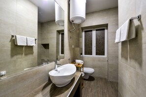 A modern bathroom with a large sink, toilet, and a small window. - Apartments Savamala center (Belgrade)