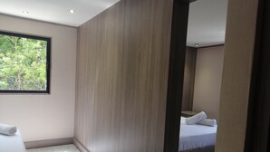 A modern hotel room with a large window, a wooden accent wall, and a neatly made bed. - Nikis place a nice place to be relax at the riviera maya (Playacar)