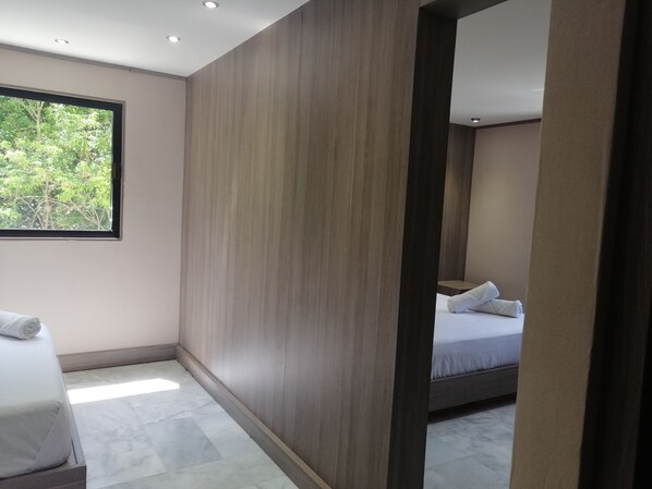 Une chambre d’hôtel moderne avec une grande fenêtre, un mur d’accent en bois et un lit parfaitement fait.