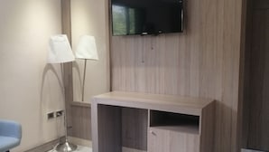 A modern room with a flat-screen TV mounted on the wall, a wooden desk, and a blue chair. - Nikis place a nice place to be relax at the riviera maya (Playacar)