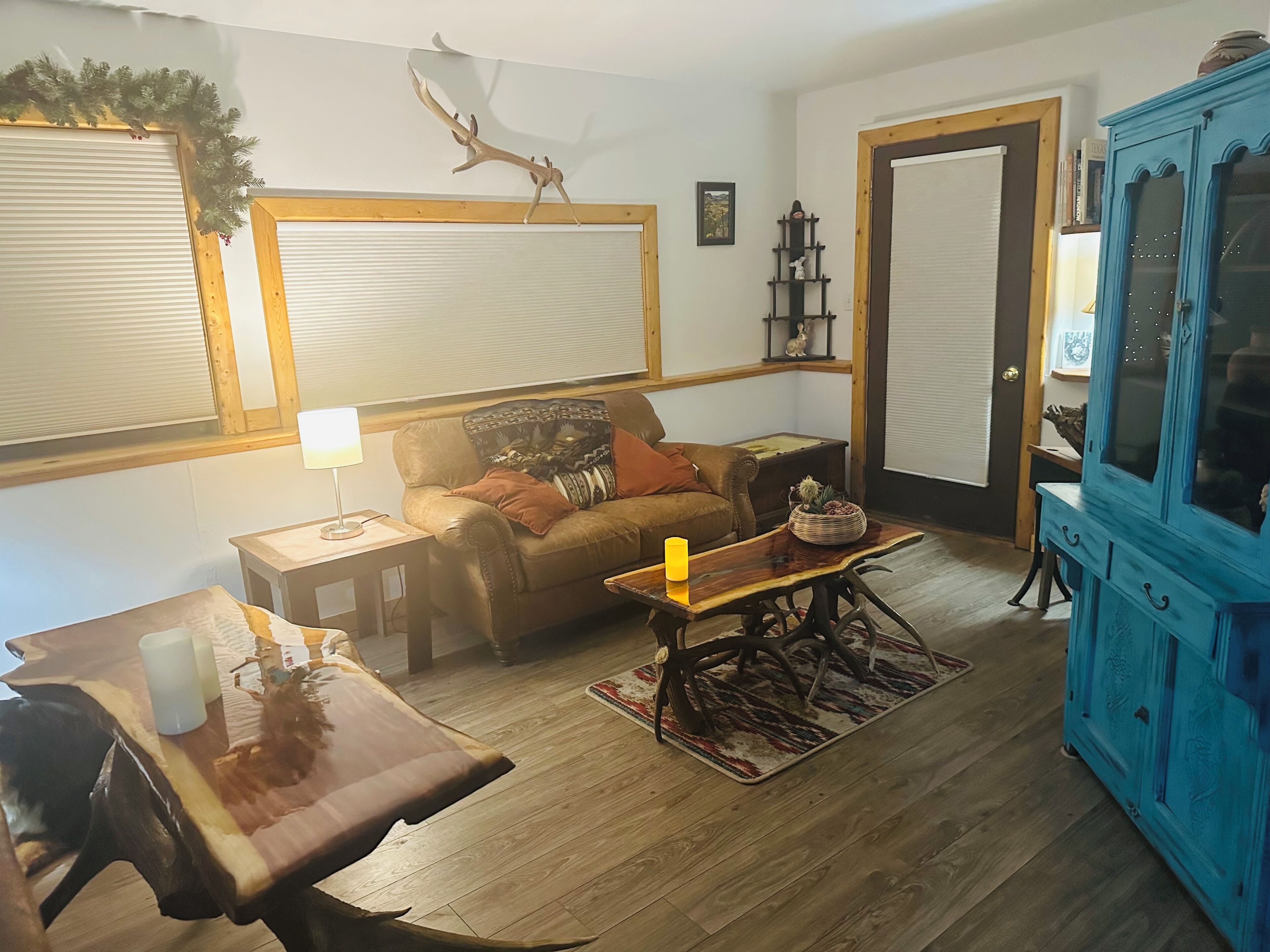 A cozy living room with a sofa, a wooden coffee table, a blue cabinet, and a fireplace.