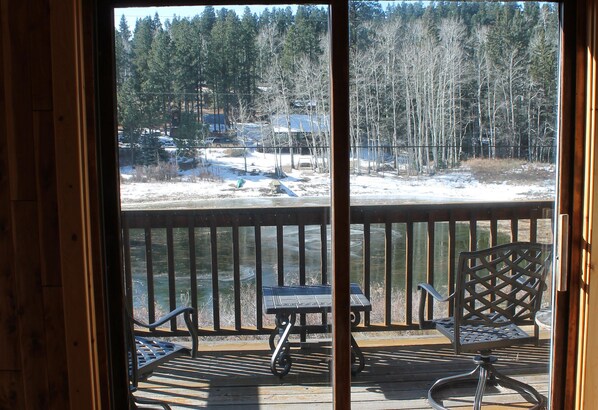 Enjoy a serene view from this deck overlooking the water and forest.