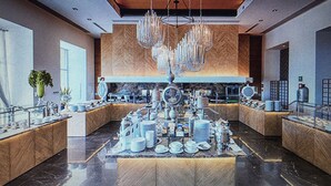 A spacious lobby with a central display of various items, large windows, and a modern chandelier.