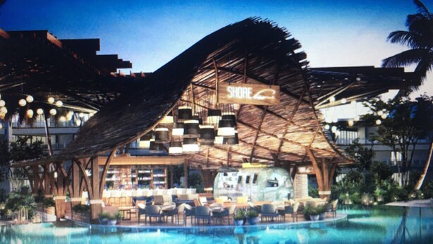 A hotel with a distinctive thatched roof structure, a pool area, and a sign reading "SHORE".