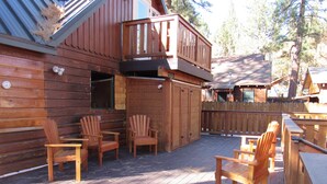 A wooden cabin with a deck, outdoor seating, and a fenced yard. - 2+2, Spa, Sleeps 6, Walk 2 Hiking & Biking Trails, Pet Friendly on North Shore (Big Bear)
