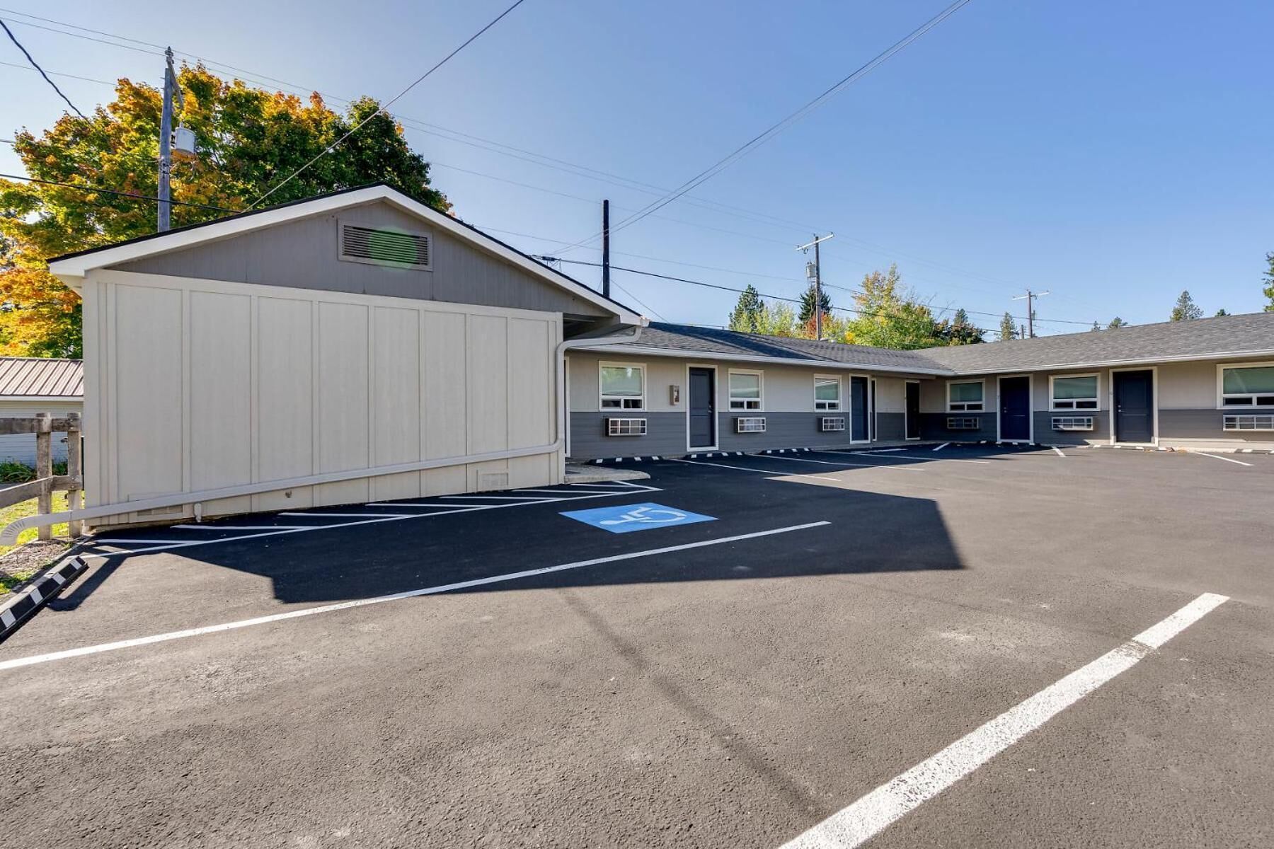 Un motel doté d’un parking, d’un espace extérieur abrité et d’une rangée de chambres équipées de climatiseurs.